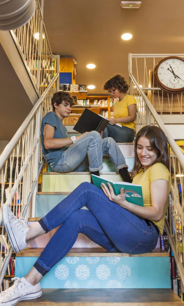 teen-girl-reading-book-steps-near-friends